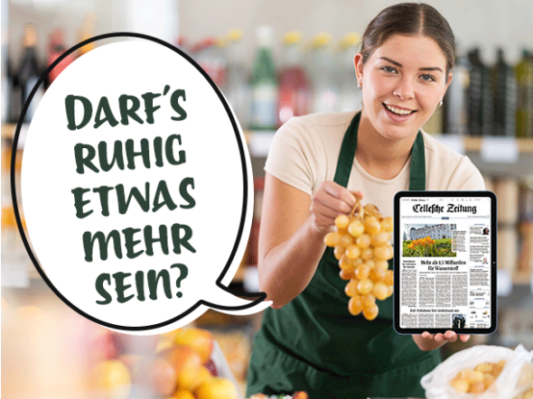Verkäuferin mit grüner Schürze hält Weintrauben und ein Tablet mit dem E-Paper der CZ in den Händen.